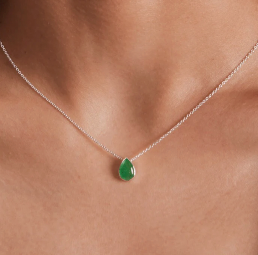closeup of green jade stone in teardrop shape on silver necklace