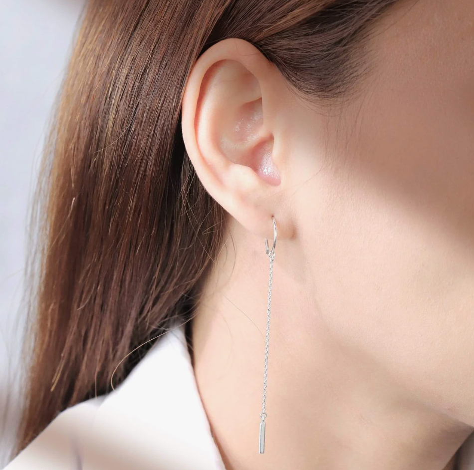 a model with light skin wearing a threader earring in sterling silver with gentle light