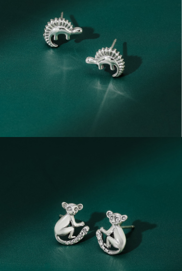 Silver hedgehog and monkey earrings on a green background